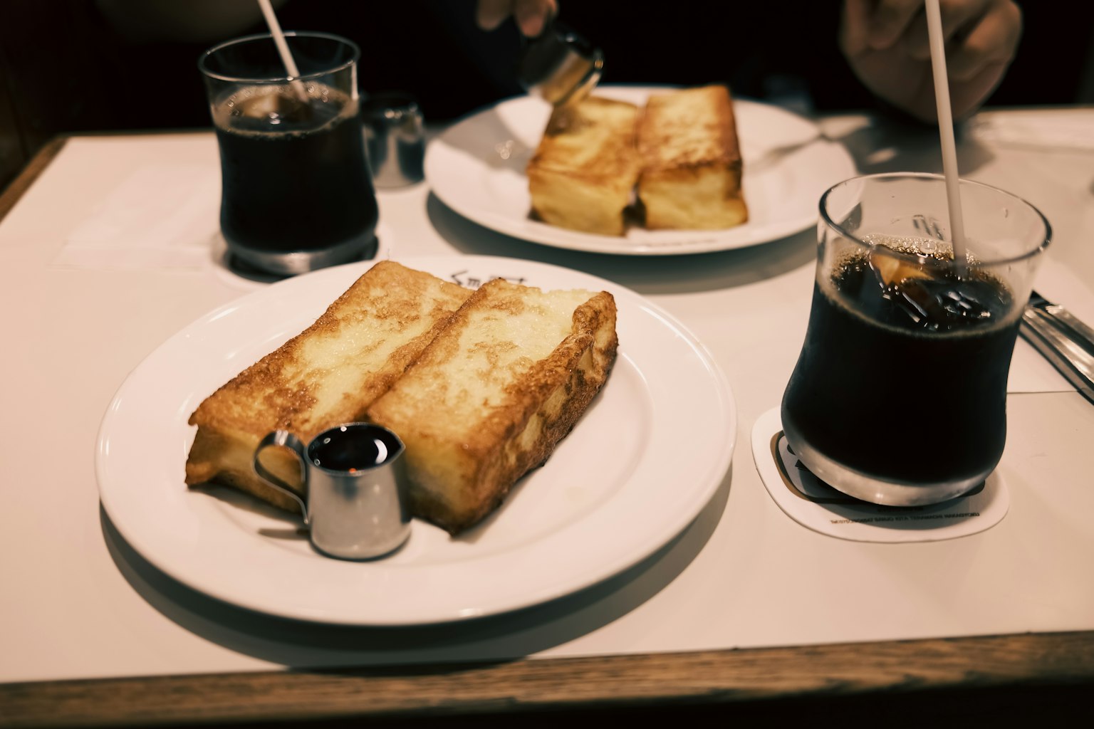 Assiettes de pain grillé avec du sirop et verres de café glacé sur une table