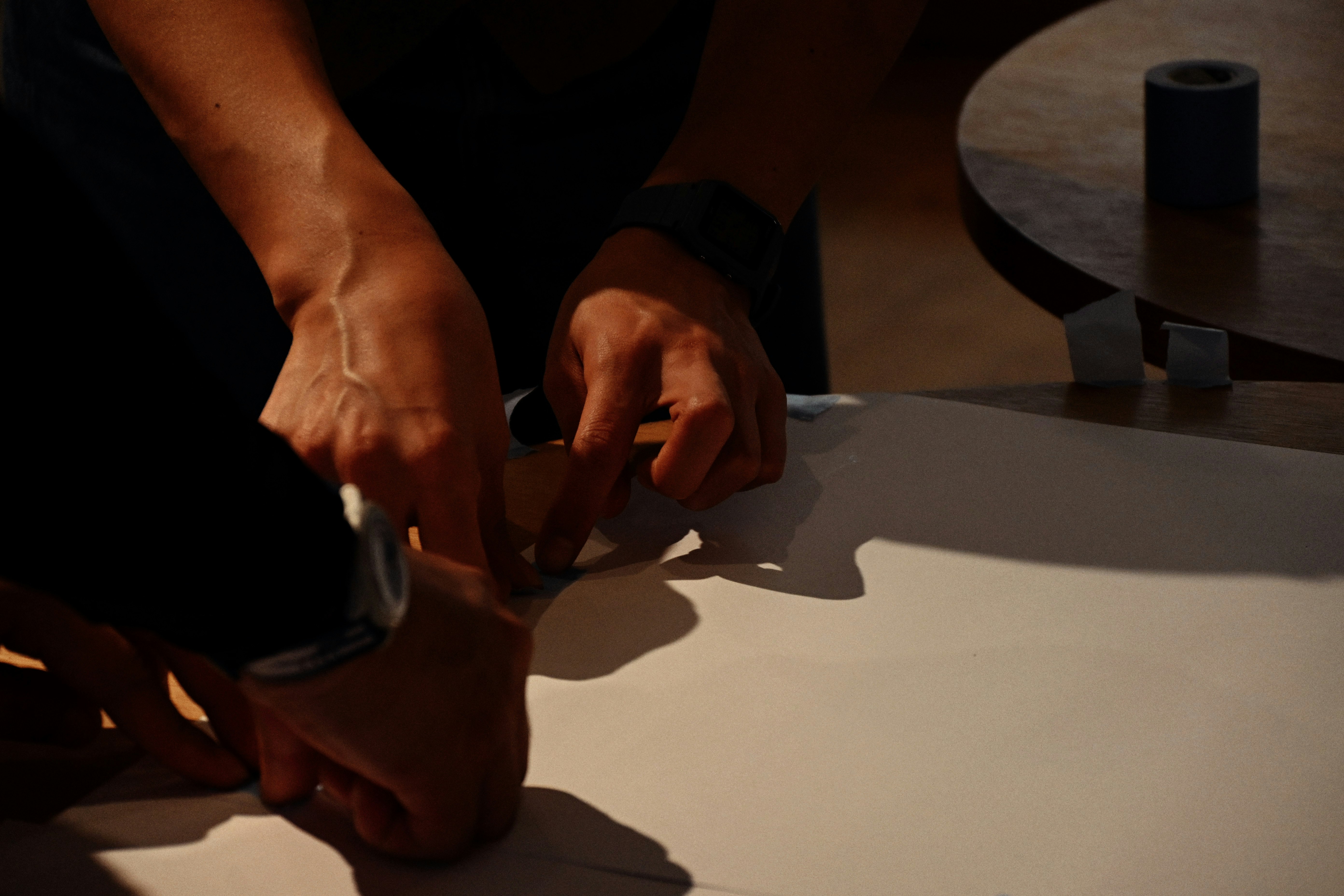 manos doblando papel sobre una mesa