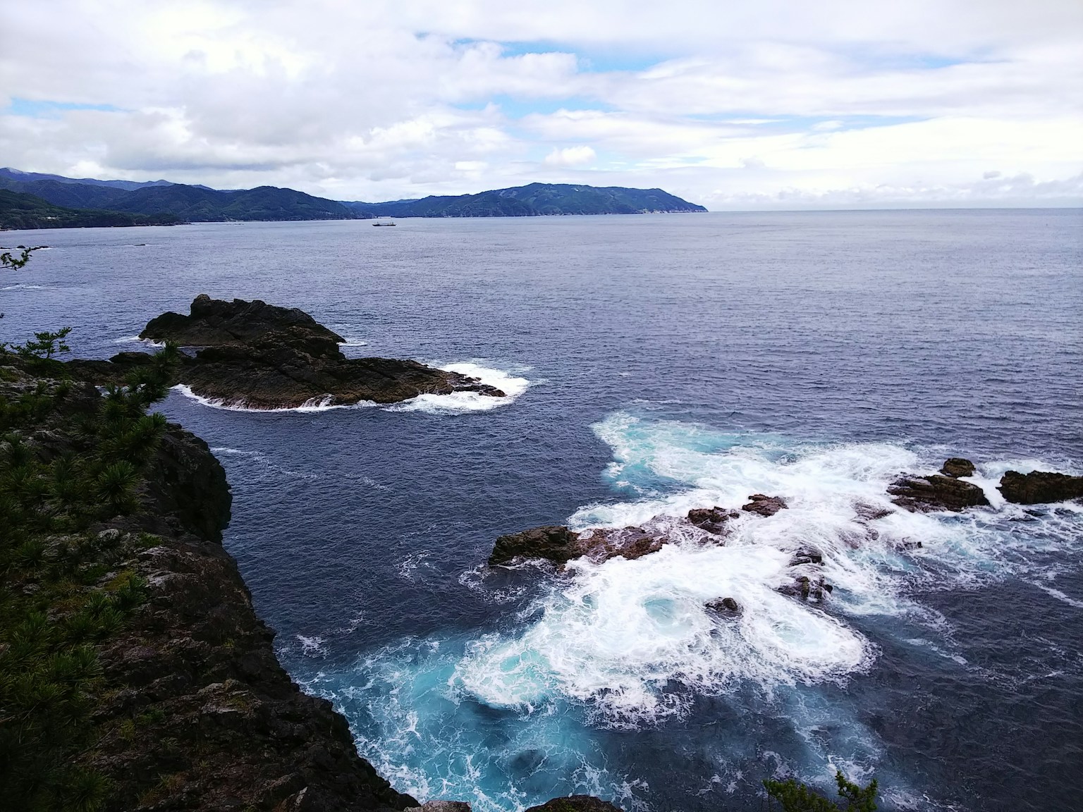 Coastal view featuring rocky shore and crashing waves