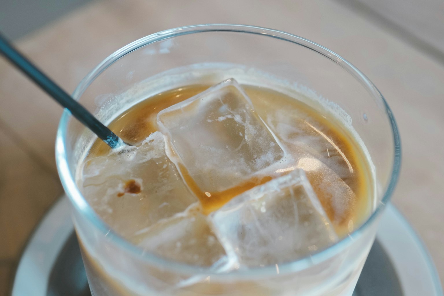 Verre de café glacé avec des glaçons et une paille