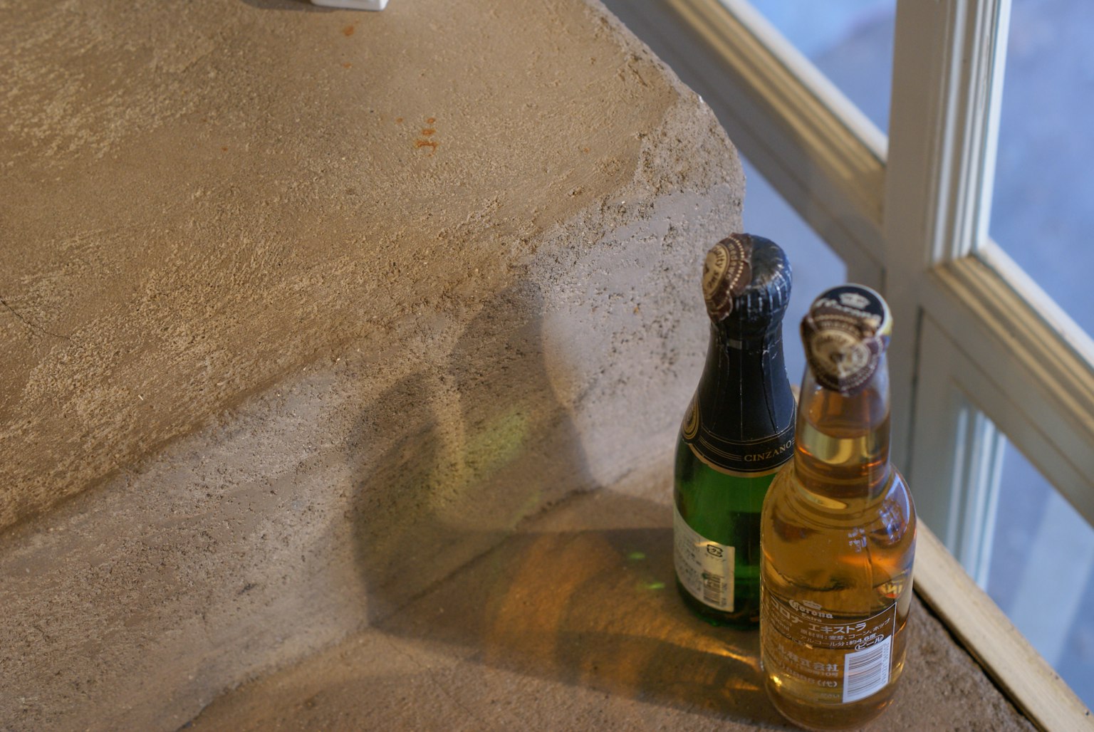 樓梯上放置的兩瓶飲料一瓶綠色一瓶黃色