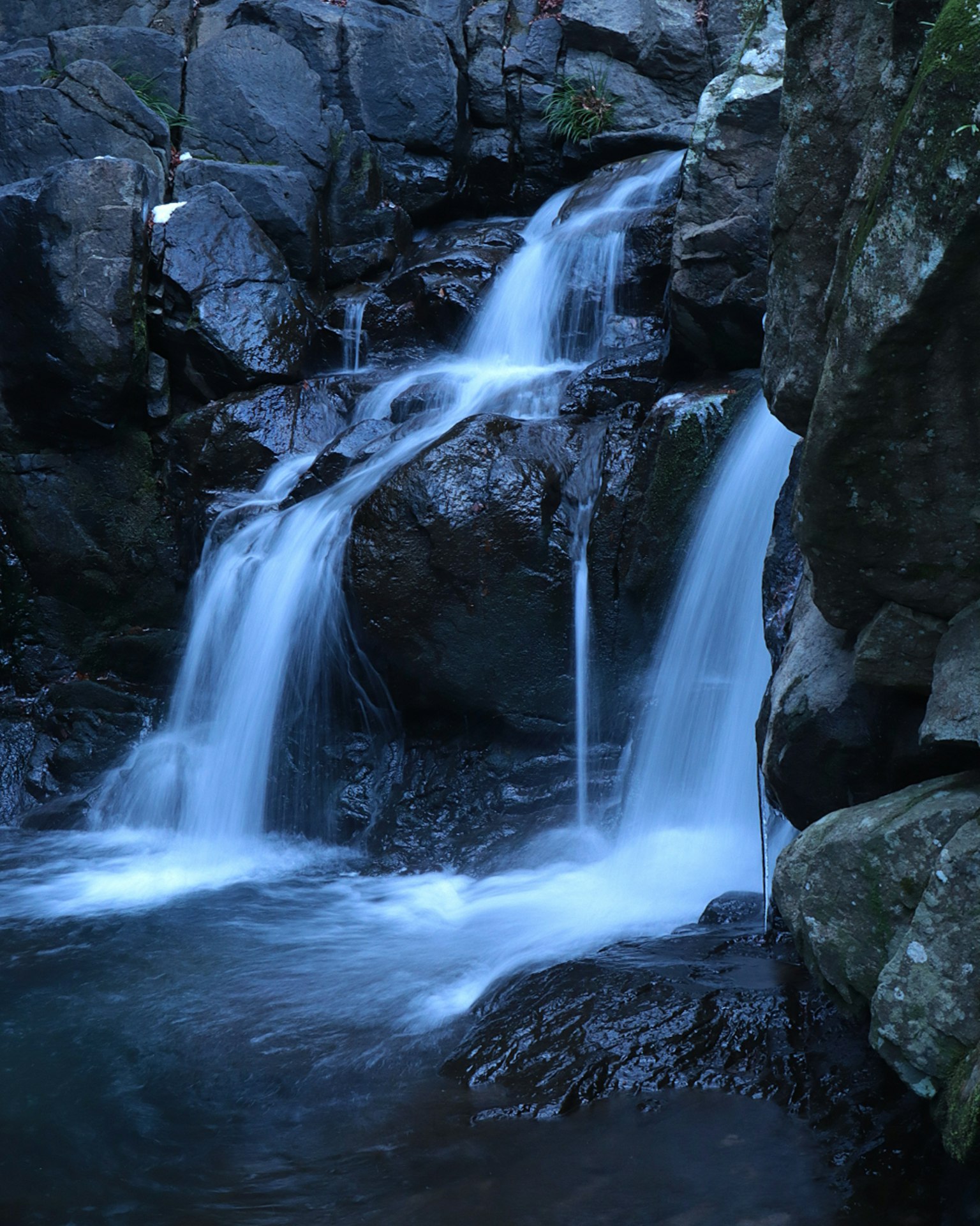 Beautiful scene of a small waterfall flowing over rocks