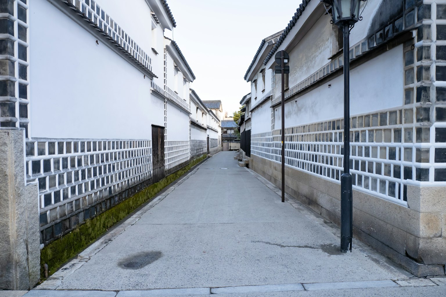 Allée tranquille bordée de murs blancs et de pavés