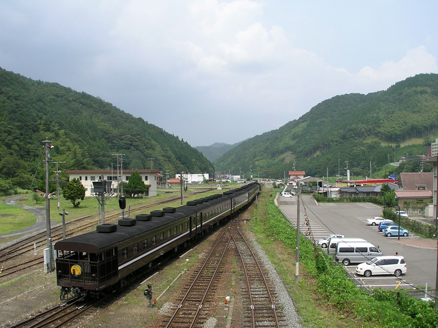 ทิวทัศน์ของทางรถไฟที่มีภูเขาล้อมรอบพร้อมรถไฟเก่า