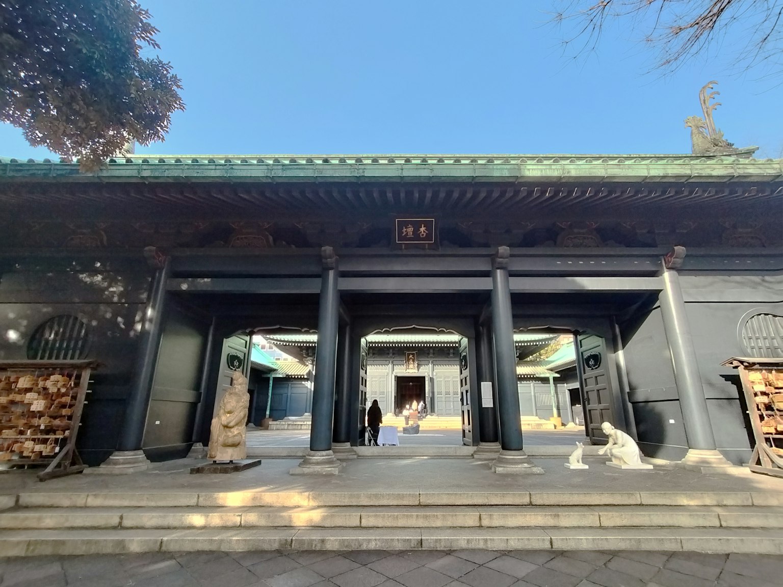 傳統建築的入口 黑色牆壁和綠色屋頂 人們在前面走