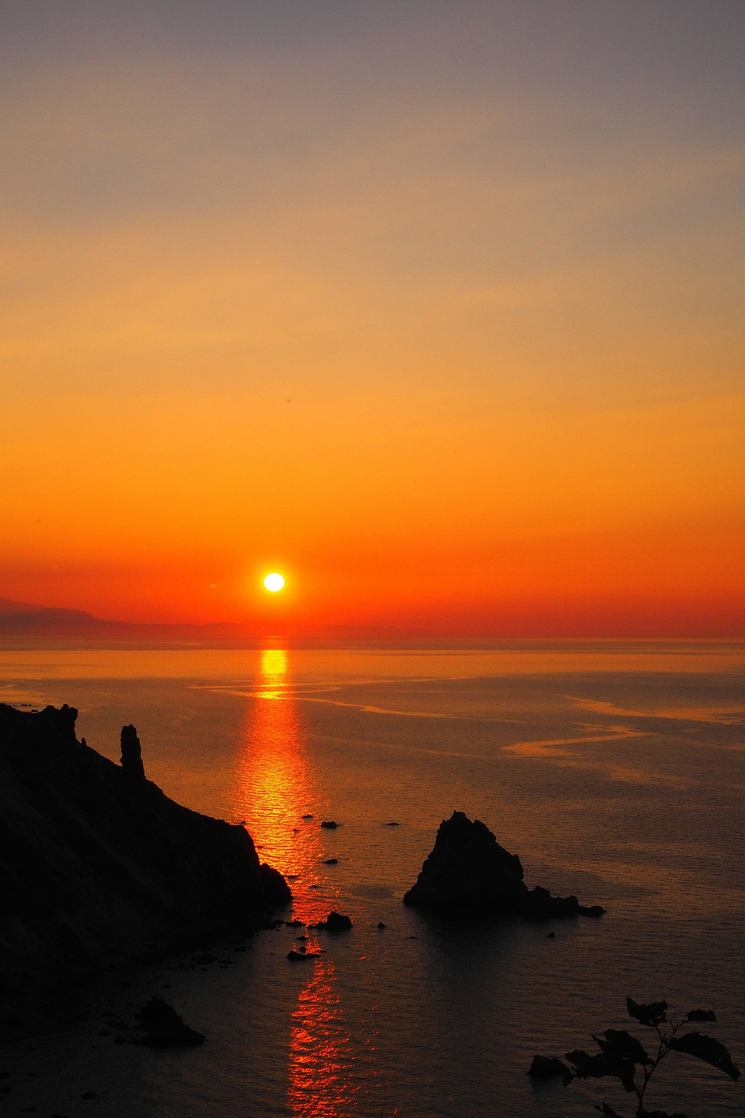 Beautiful landscape of the sunset over the sea with coastal rocks and reflected light