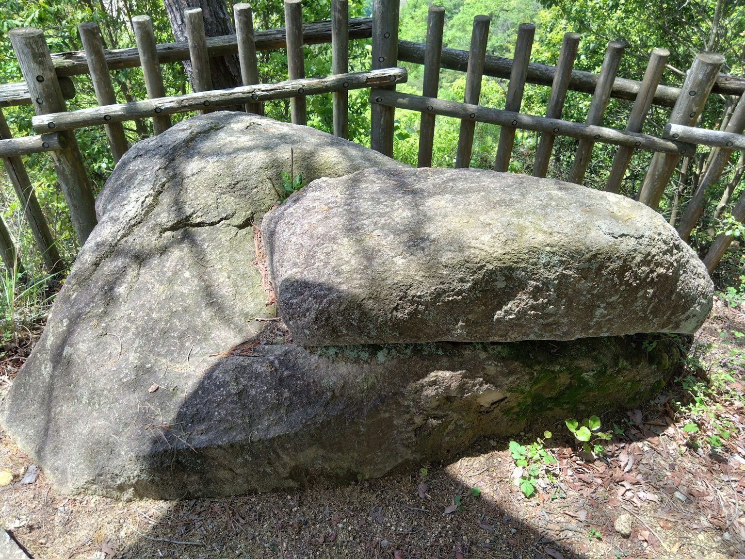 Großer Stein mit einem Holzzaun in einer natürlichen Umgebung