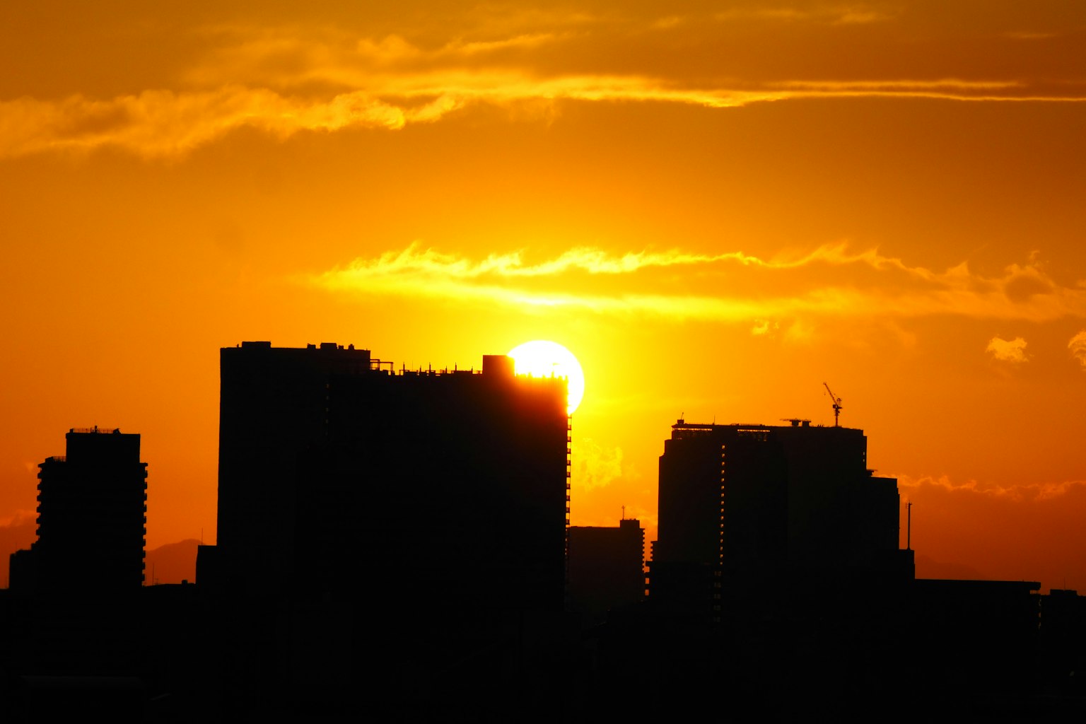 Silhouette de la ligne d'horizon de la ville au coucher du soleil