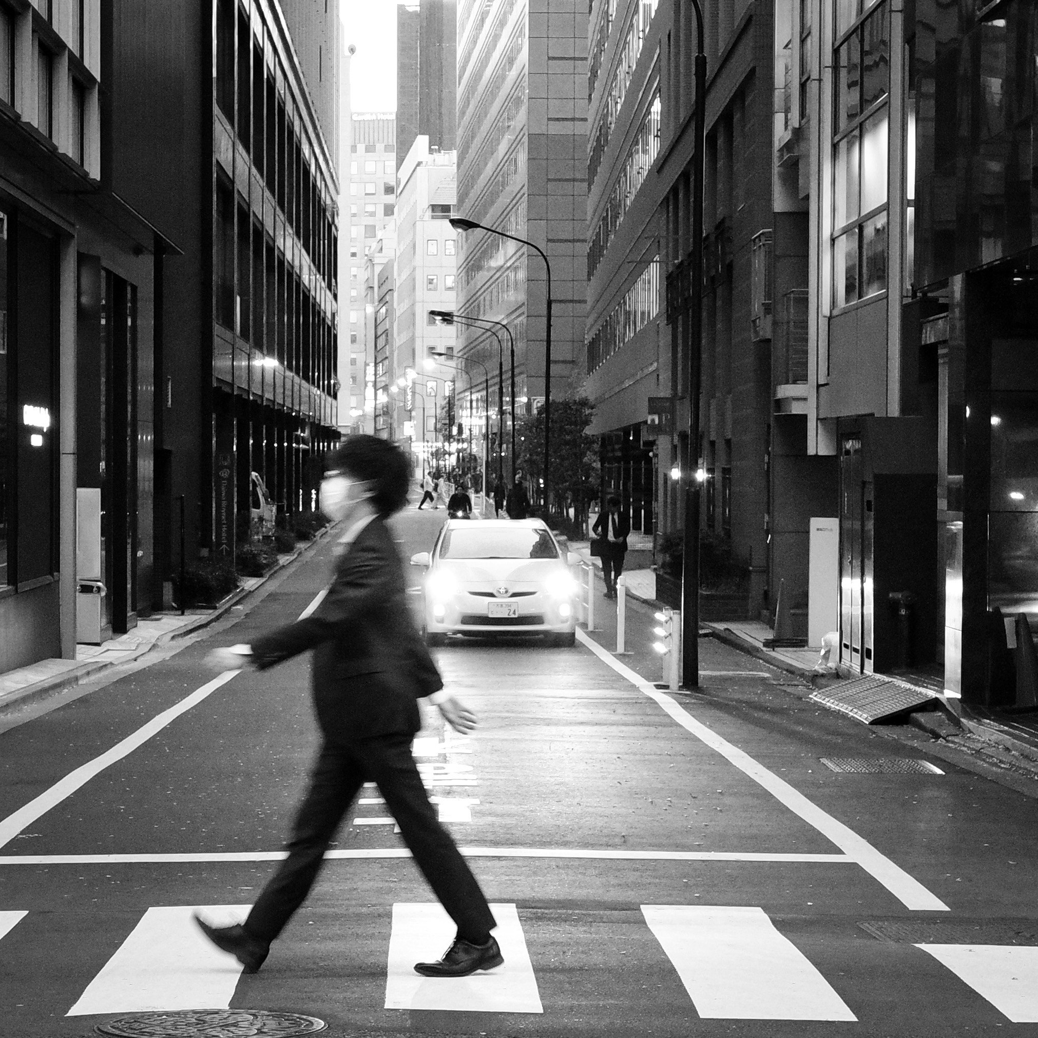 東京の横断歩道を歩く人々のモノクロ都市風景