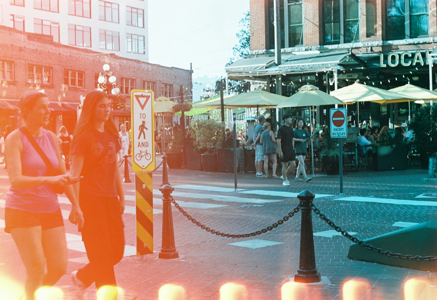 街を歩く二人の女性とカフェのテラスがある風景