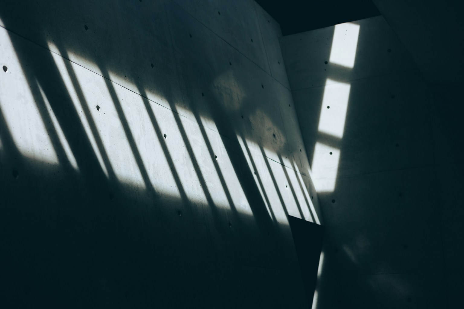 Strisce di luce e modelli di ombra su un muro scuro