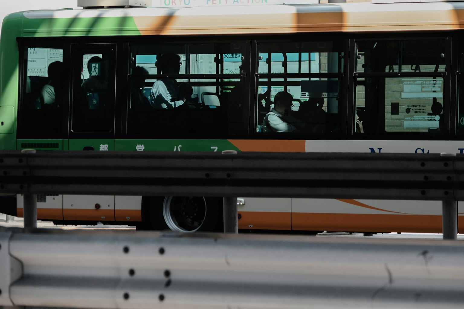 Un autobús circulando por una carretera con pasajeros visibles a través de las ventanas