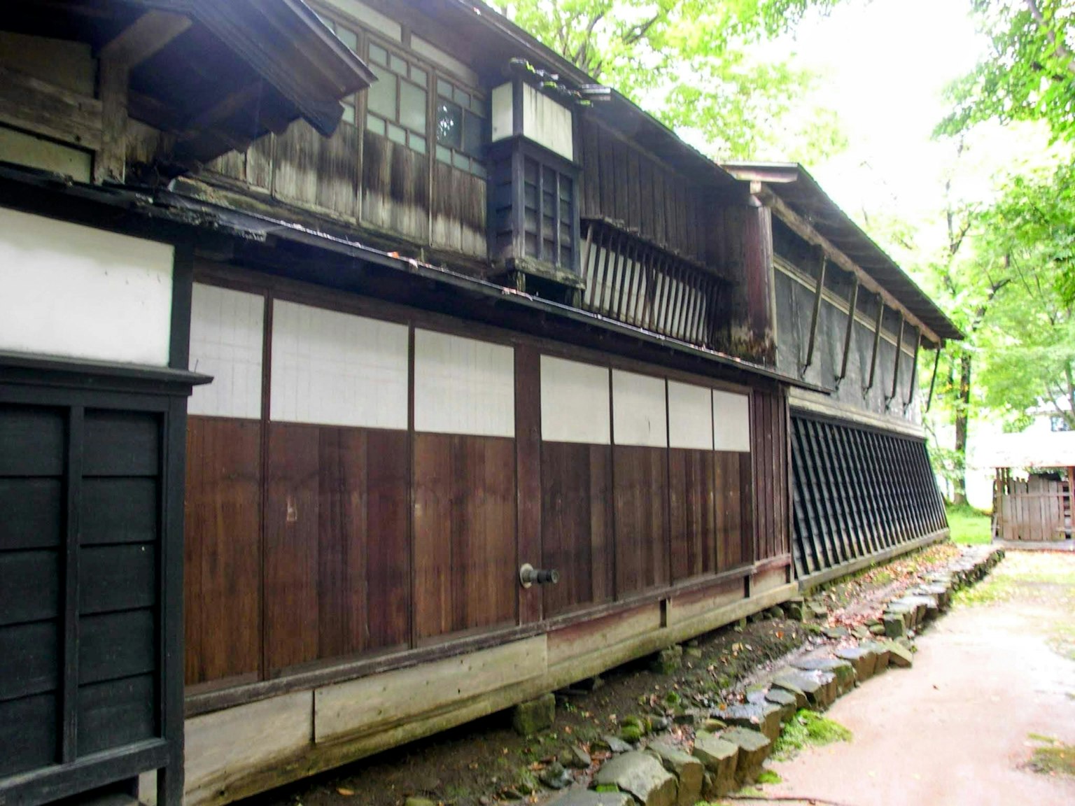 Extérieur d'un ancien bâtiment japonais avec des murs en bois et des portes coulissantes blanches