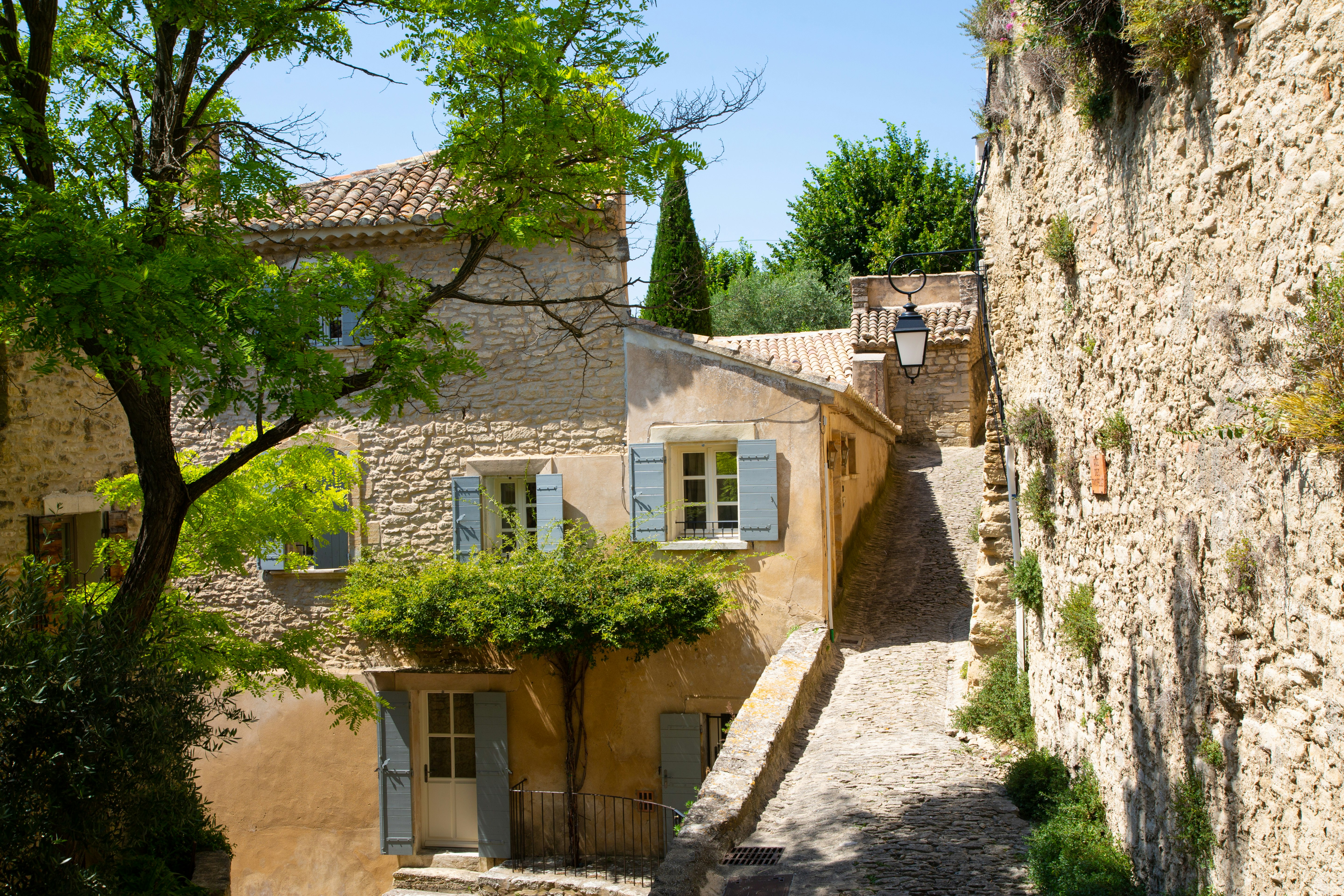stone village lane with blue-window houses
