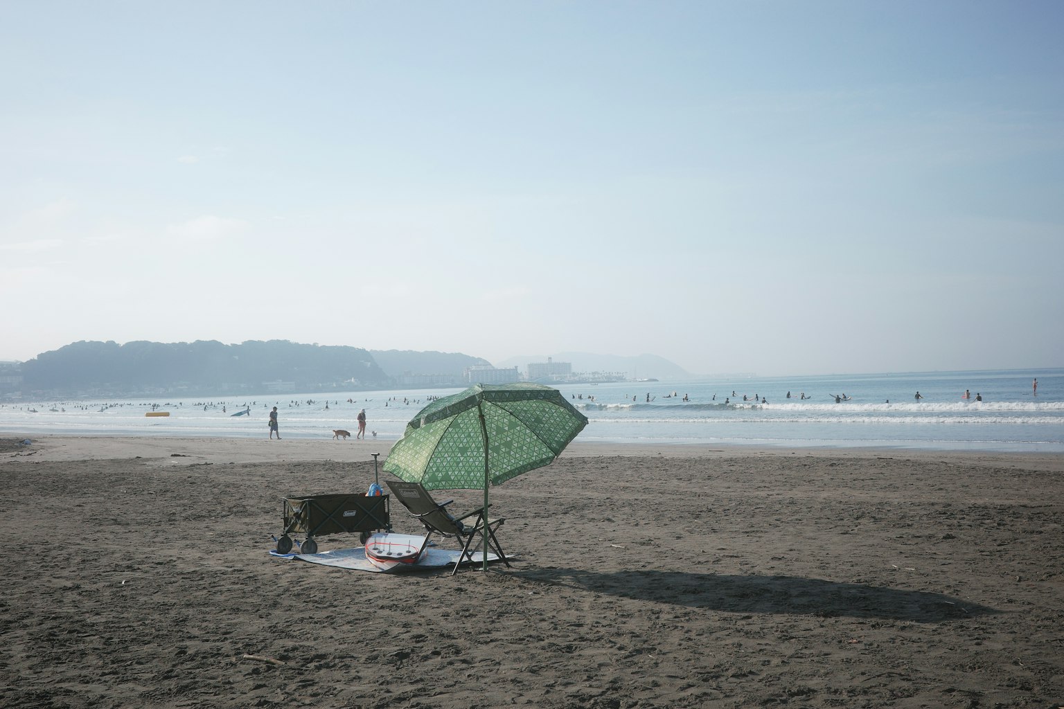 海滩场景，带有绿色伞和沙滩椅