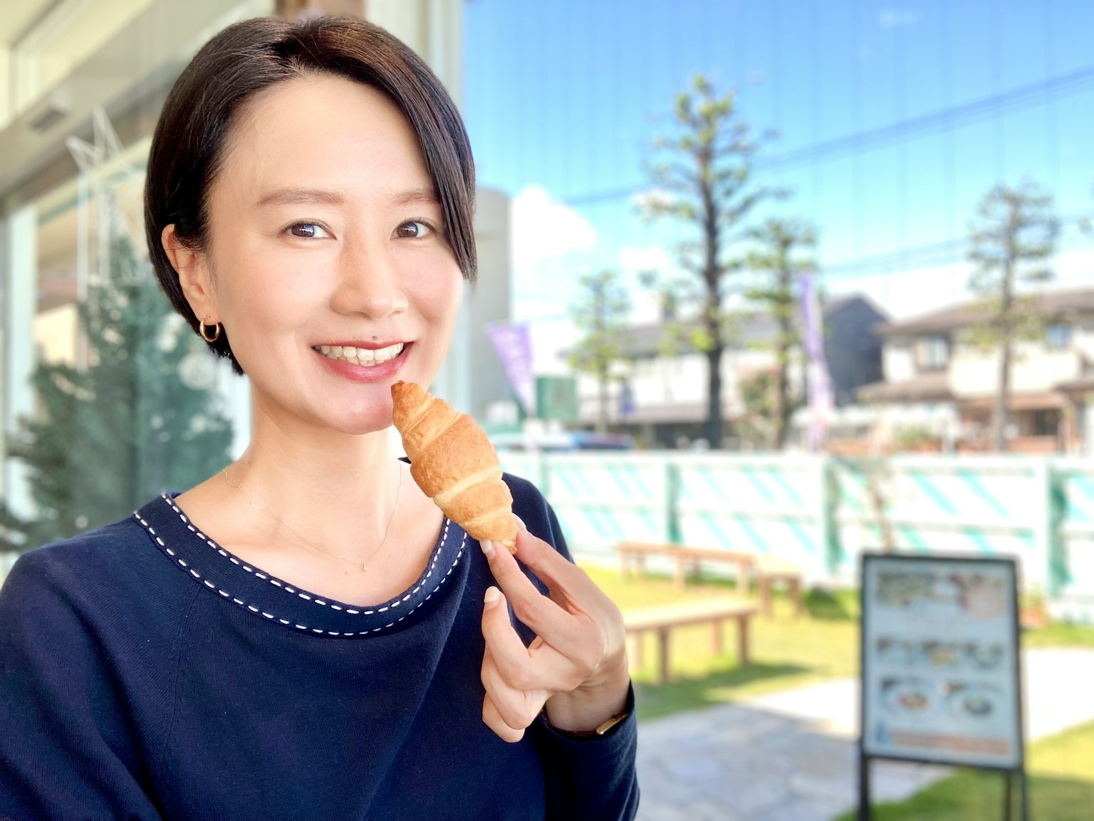 Una donna sorridente che tiene un cono gelato con uno sfondo esterno scenico
