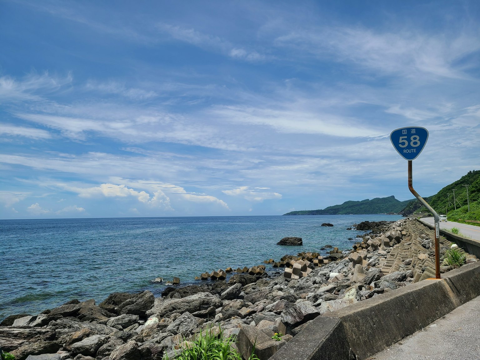 蓝色海洋和天空的风景，岩石海岸和路标