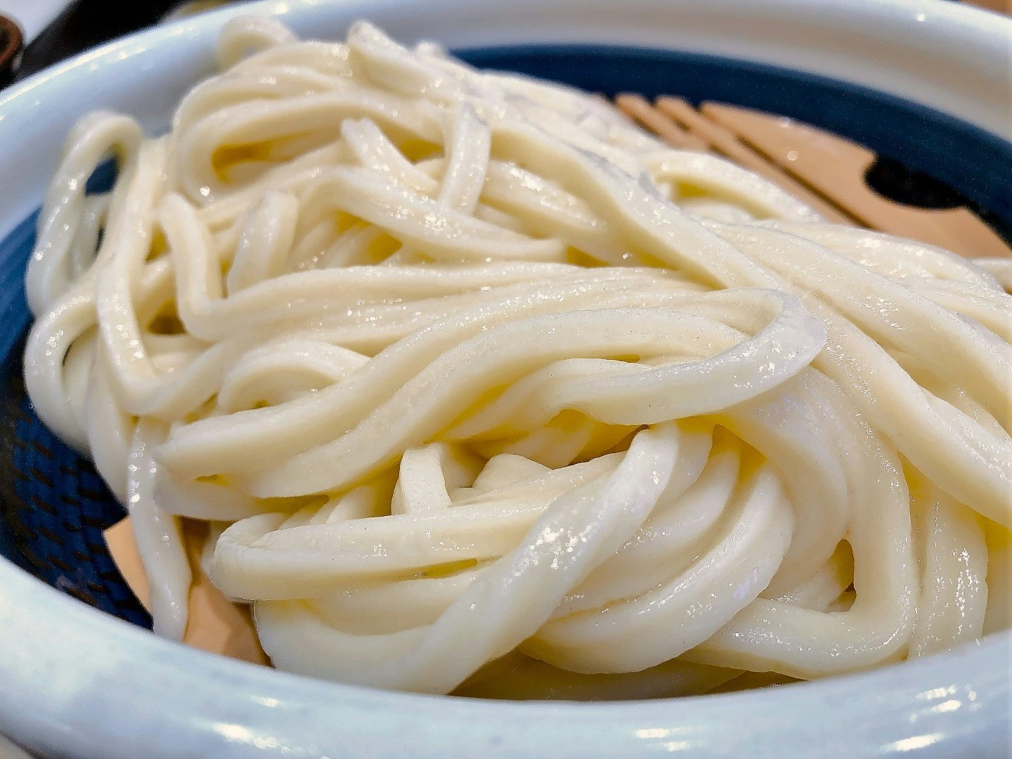 白い麺が盛られた青い器のうどん