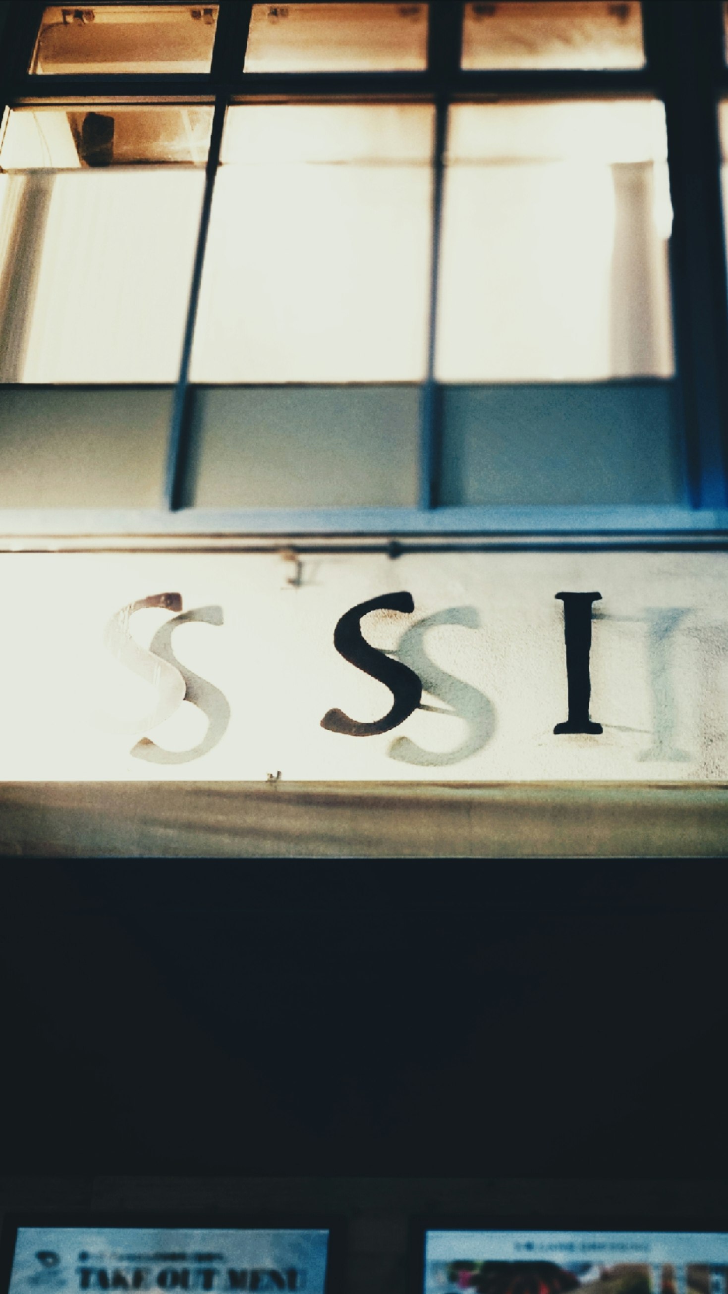 窓辺の「SSI」サインと掲示物のある室内壁面