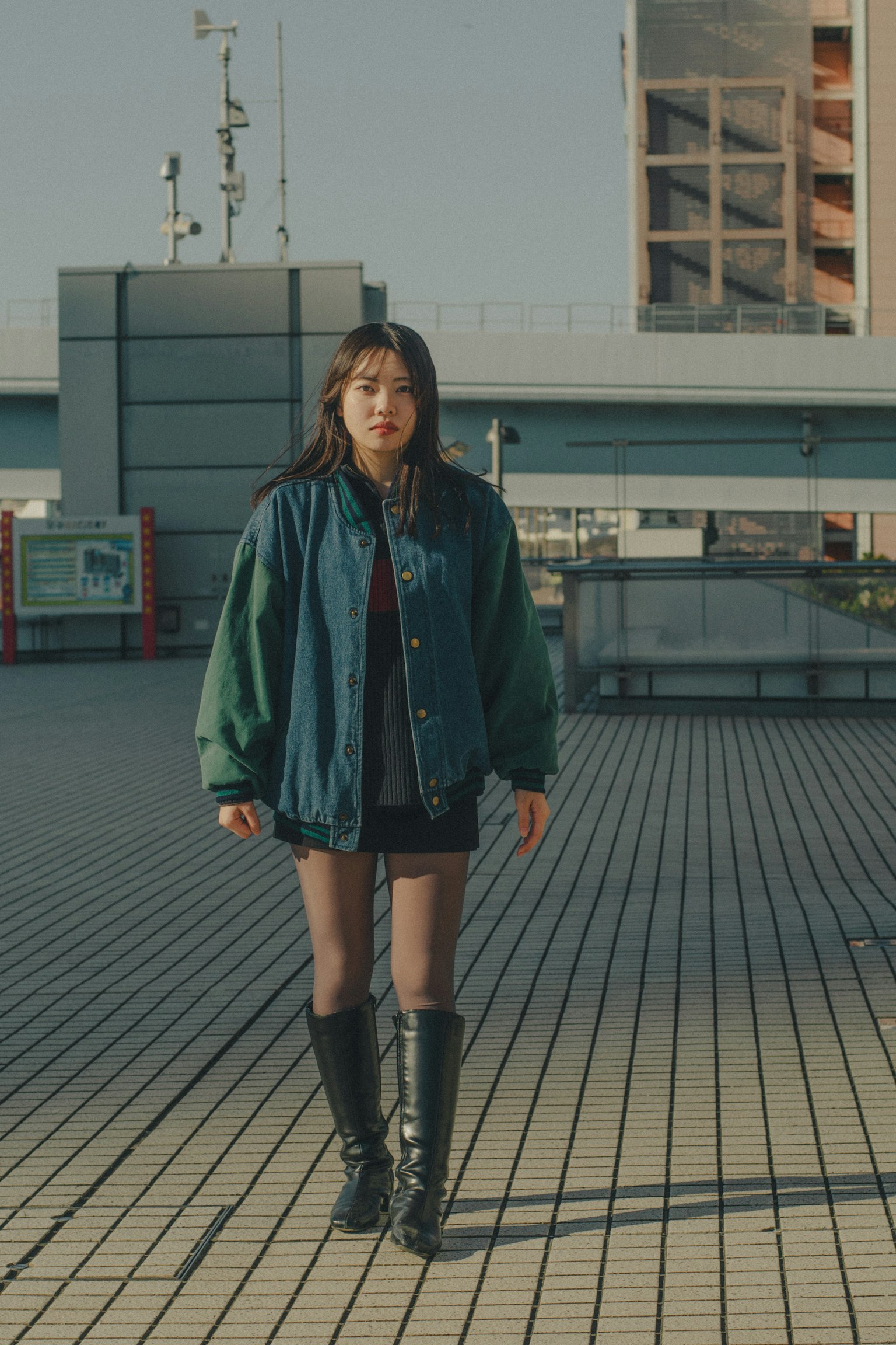 穿著藍綠夾克的女性站在戶外