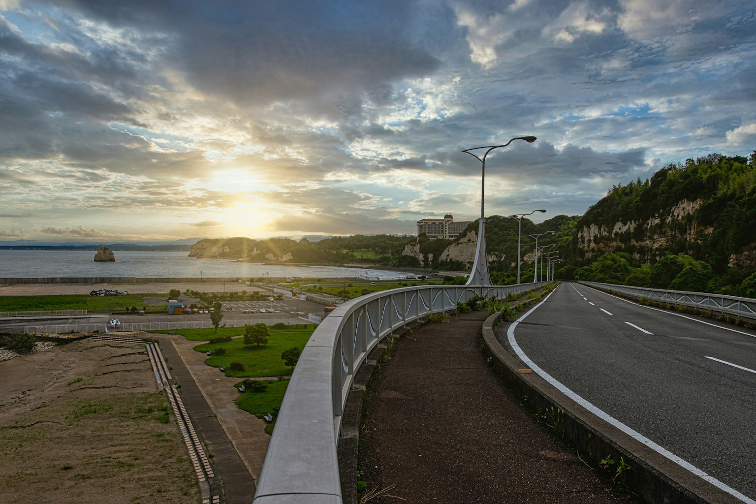Strada costiera con vista sul tramonto e paesaggio verde