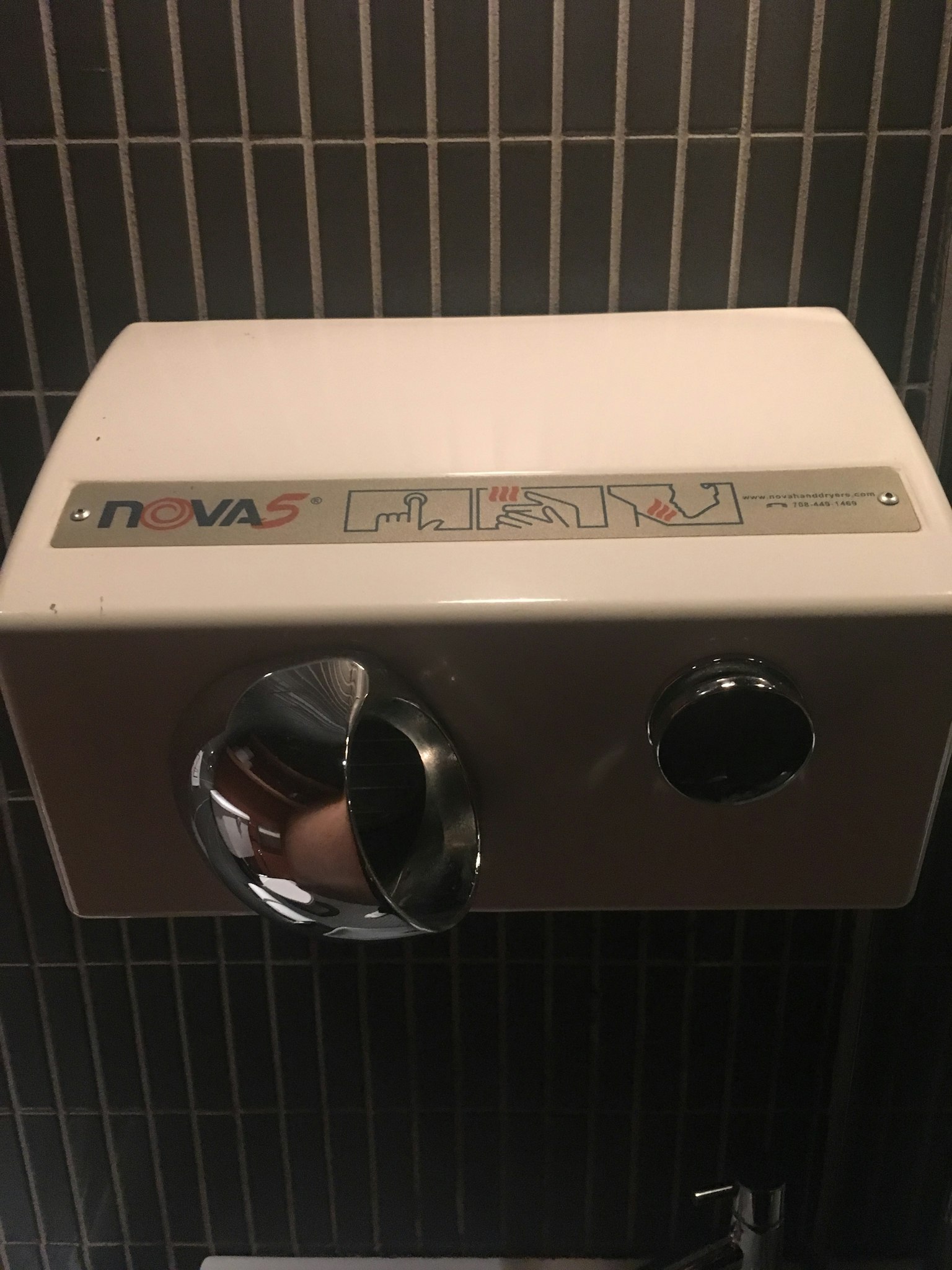 Bild eines weißen Handtrockners in einer Toilette