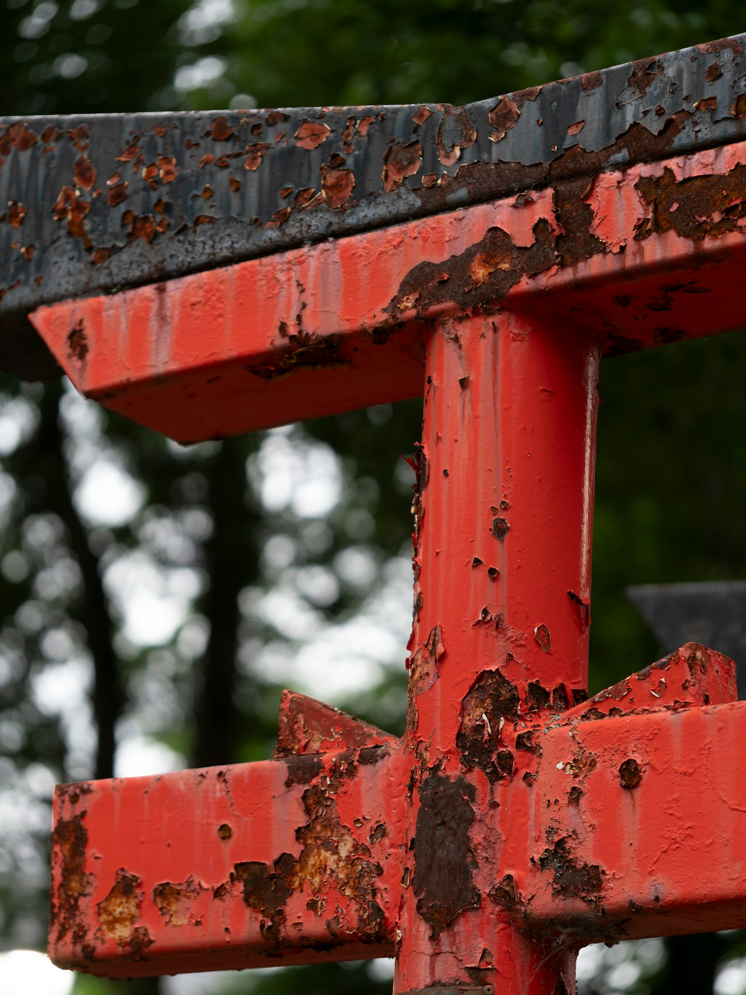 Gros plan d'un torii rouge usé montrant de la rouille et la texture du bois
