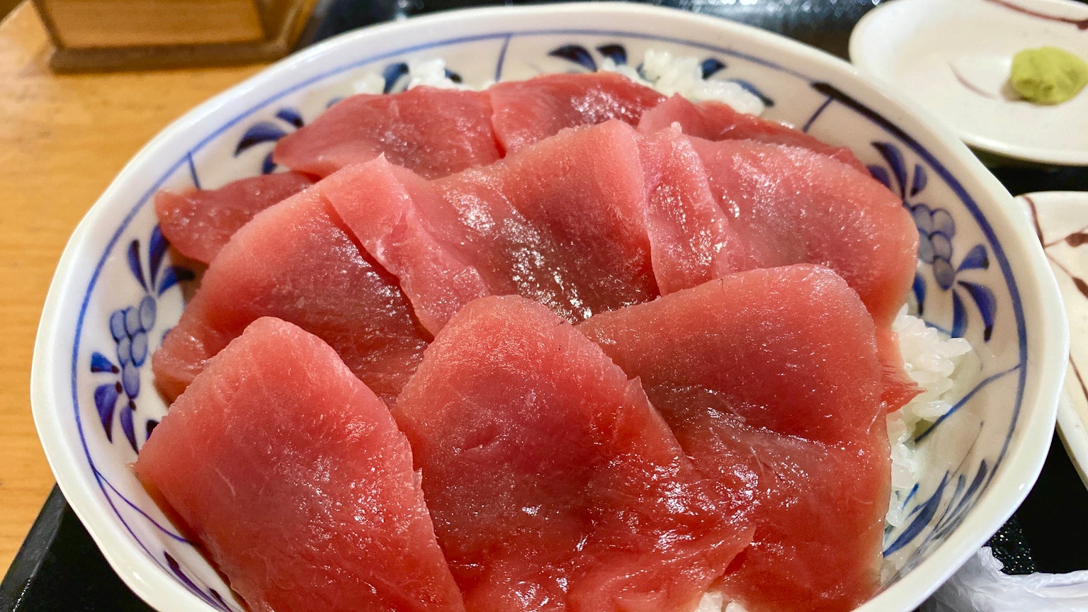 Ciotola di riso guarnita con fette fresche di sashimi di tonno