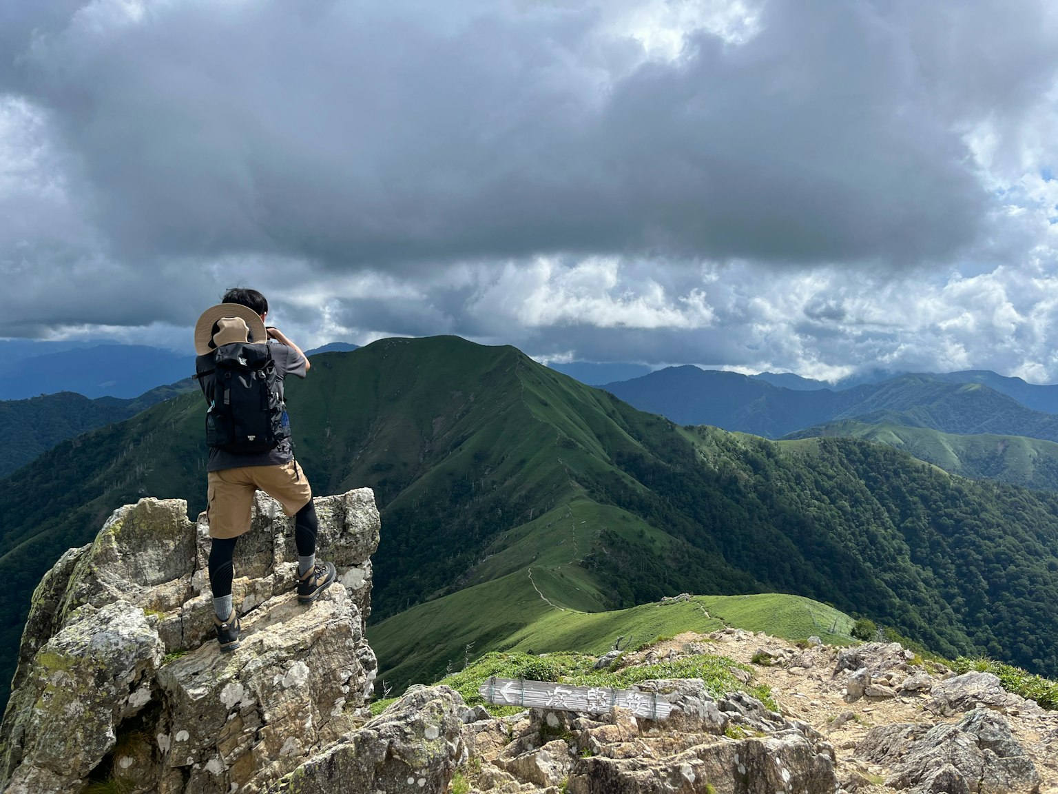 Hiker standing on a rocky peak enjoying the scenic view