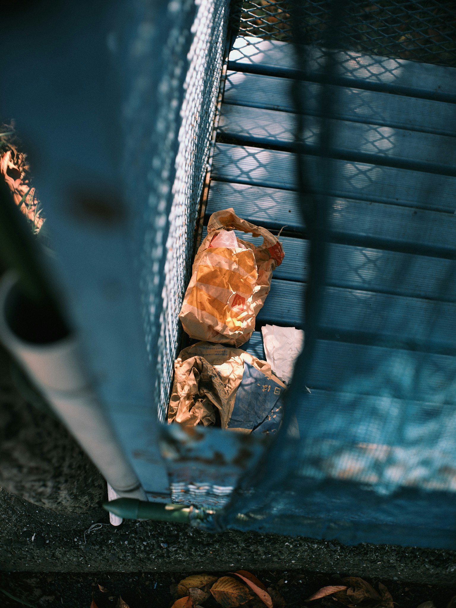 View of trash pile through blue fence