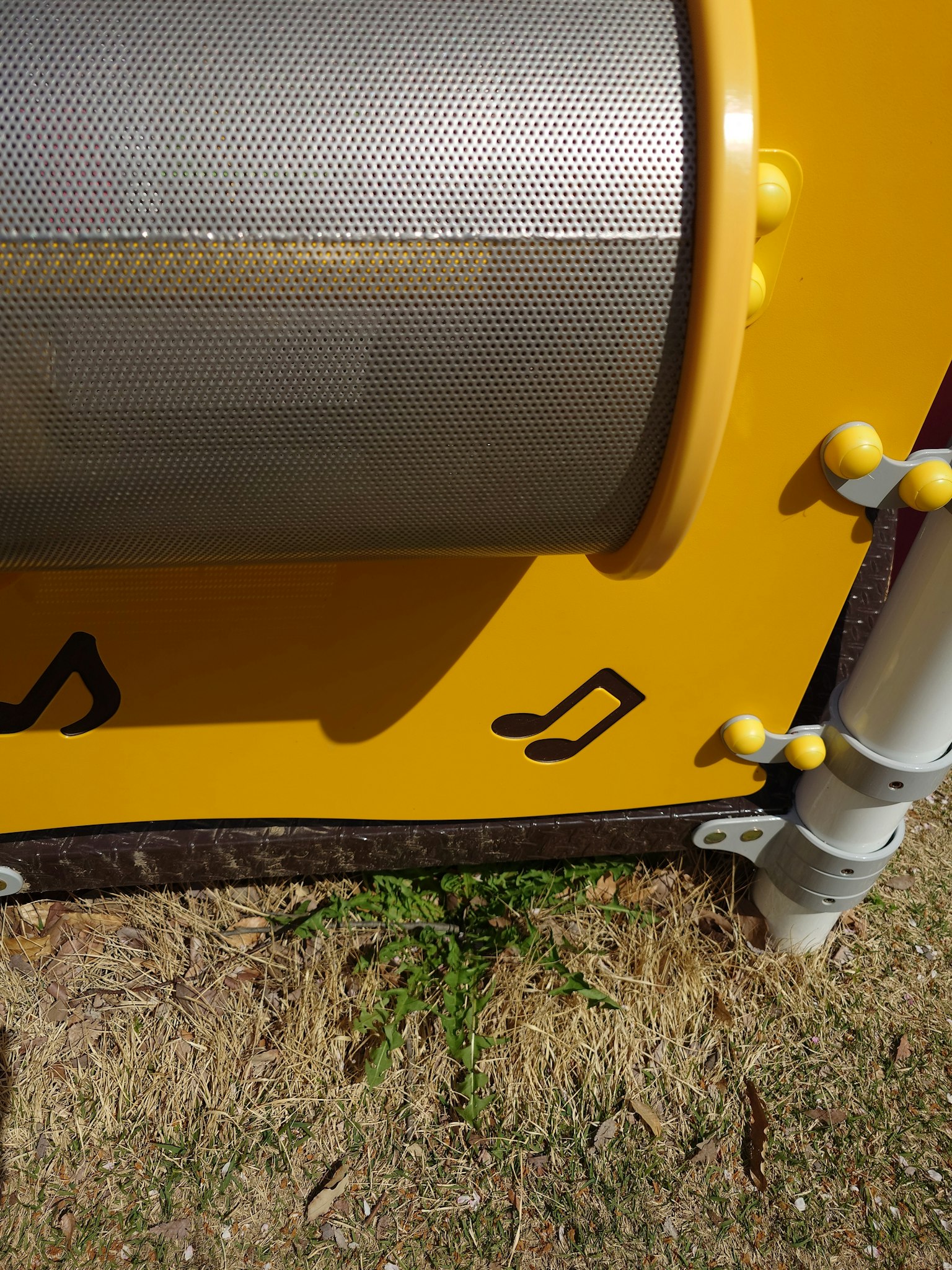 A section of yellow playground equipment featuring musical notes
