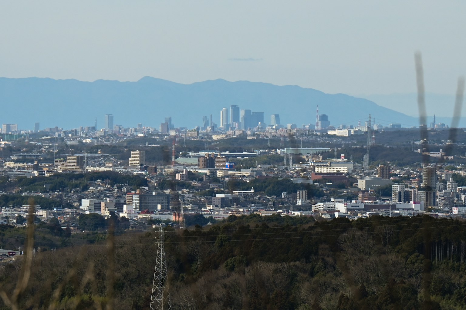 Paysage urbain avec des montagnes en arrière-plan et des lignes électriques