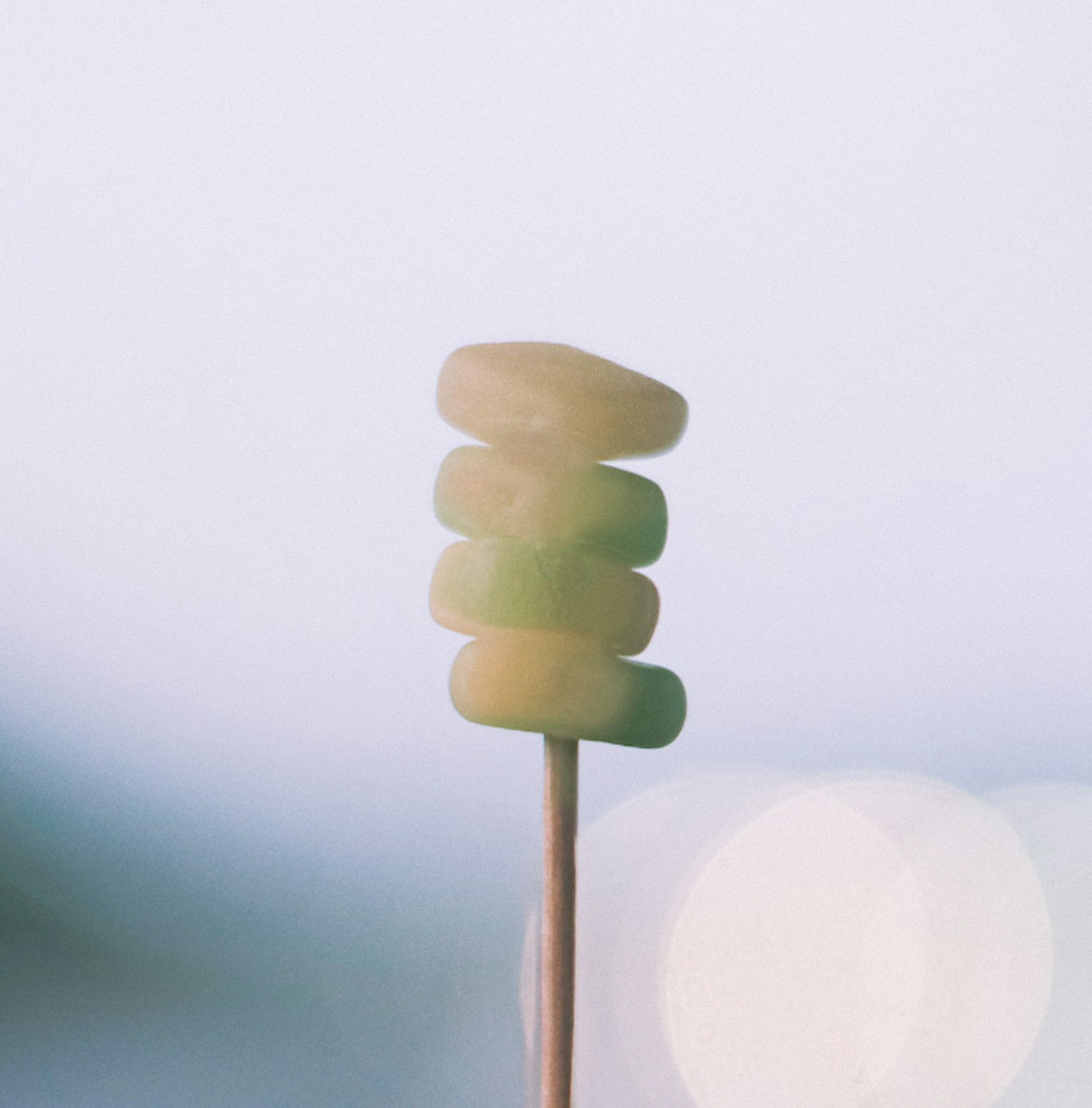 緑色の円形のスナックが串に刺さっている画像