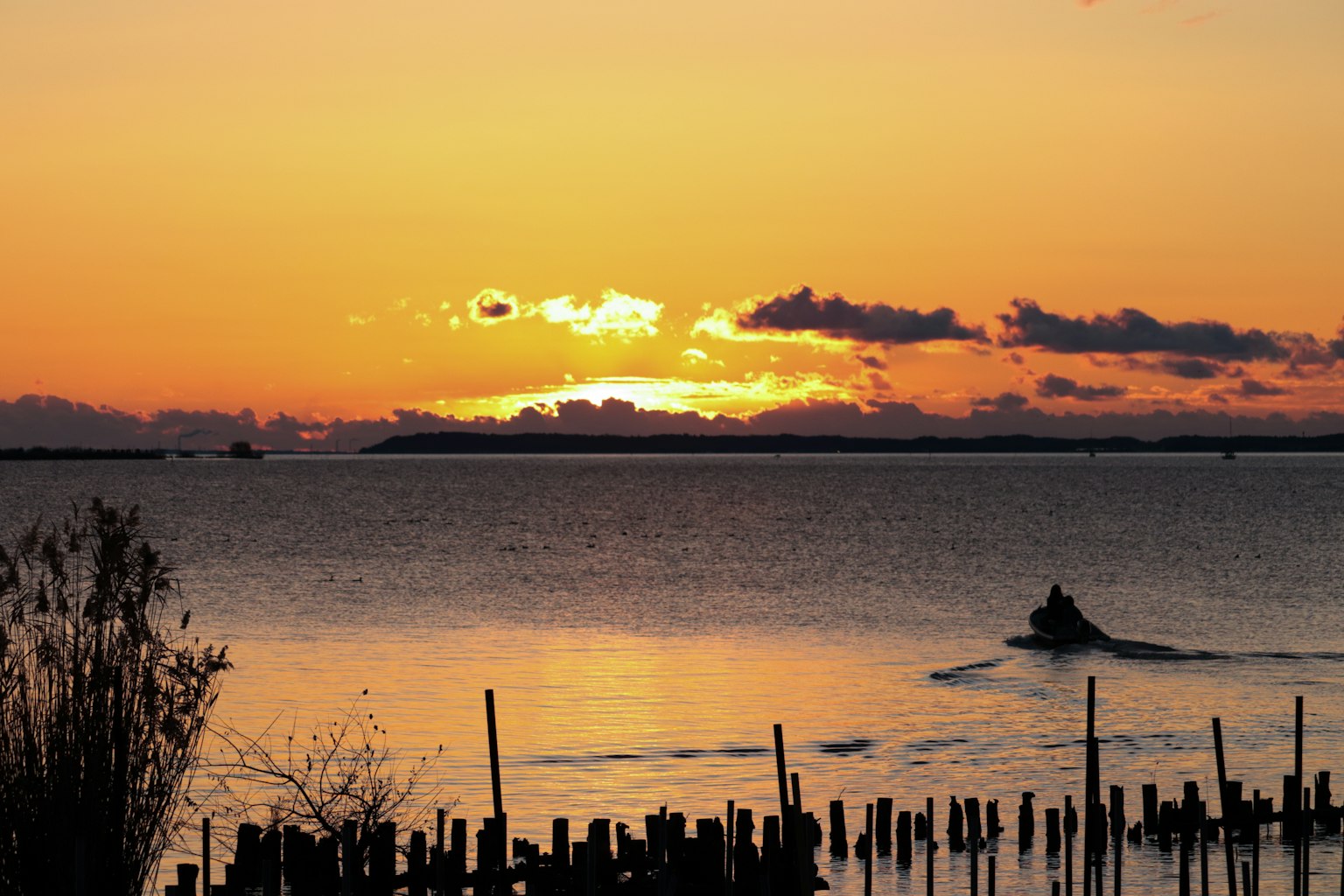 Schöner Sonnenuntergang über dem Meer mit einem fahrenden Boot