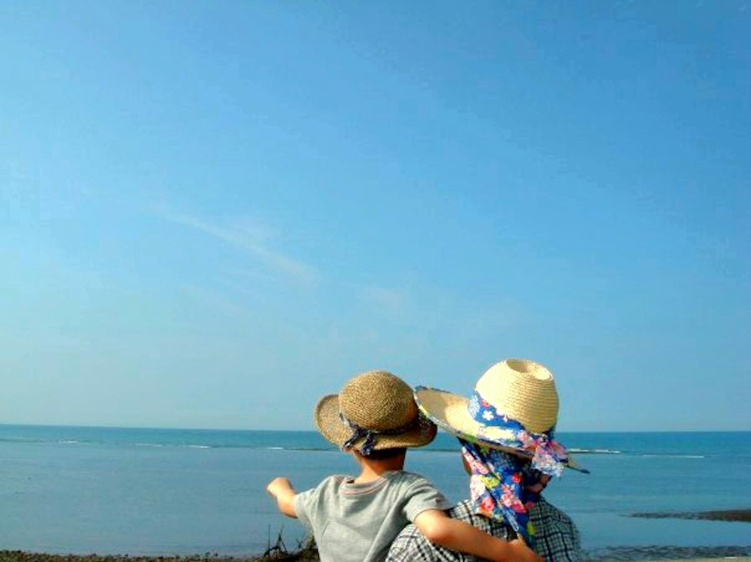 Bambini che ammirano il mare e il cielo blu