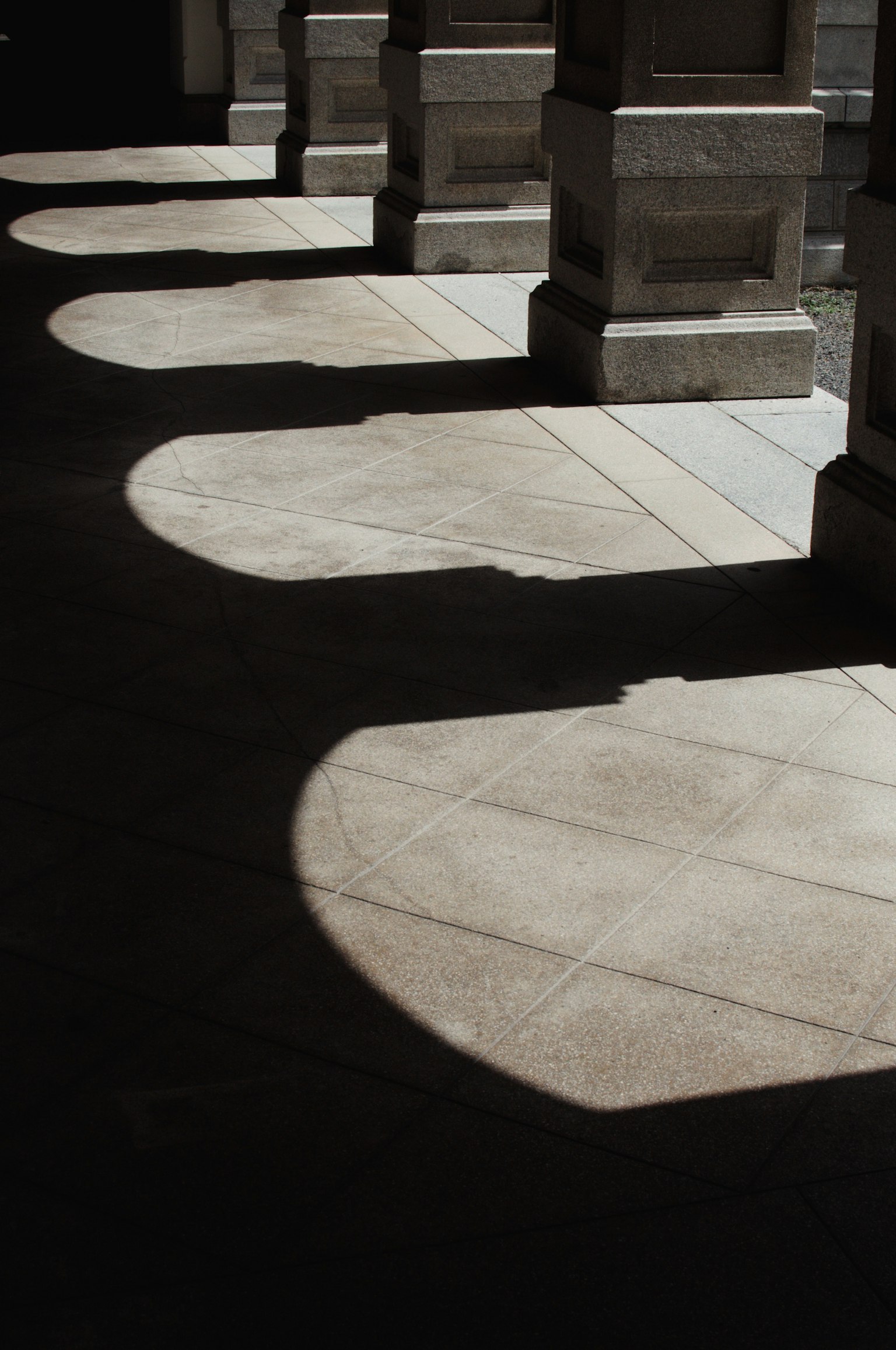 Shadows cast on the floor from a series of columns
