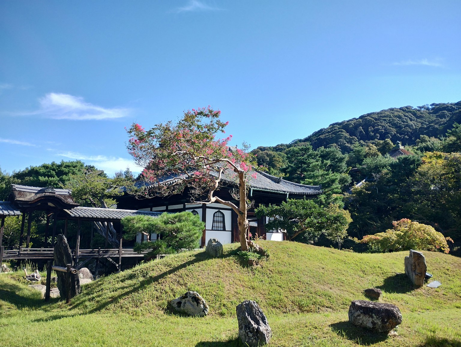 Maison traditionnelle japonaise dans un jardin magnifique avec des collines verdoyantes