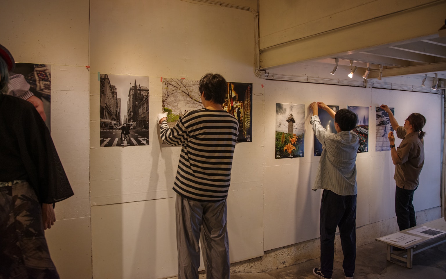 Orang-orang yang mengatur foto di galeri seni dengan fokus pada pemasangan