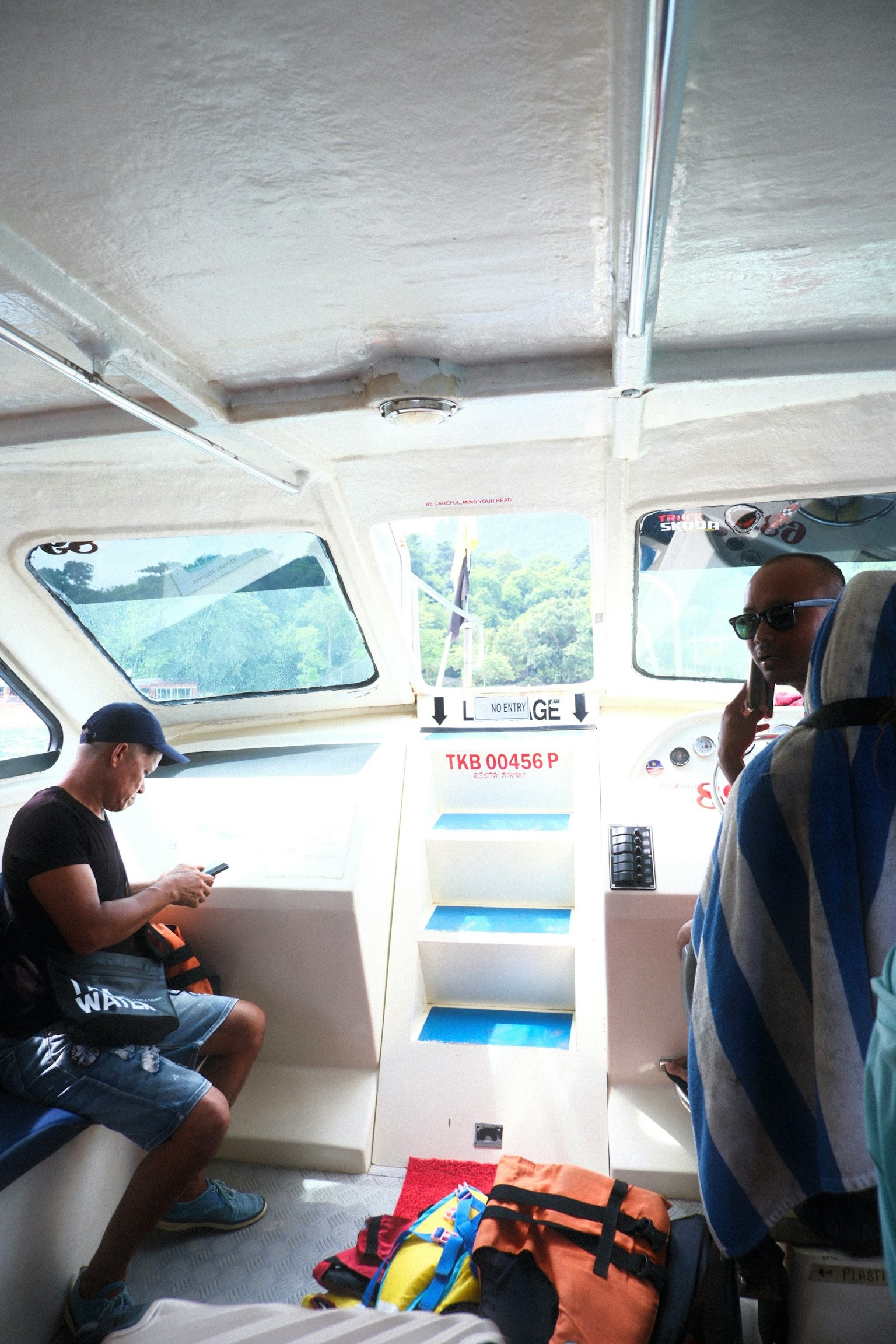 Interior kapal dengan dua pria bersantai dan handuk berwarna-warni