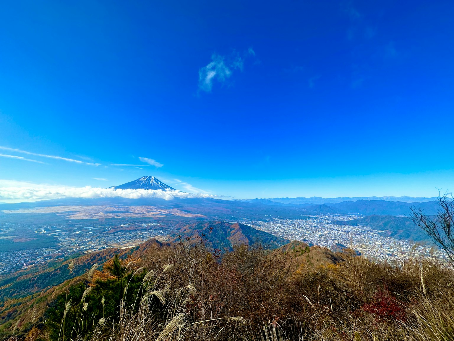 View of Mount Fuji under a clear blue sky with distant mountains