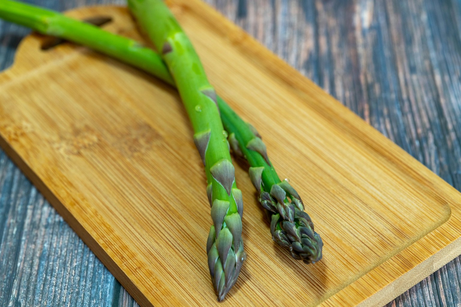 Asparagi verdi posati su un tagliere in legno