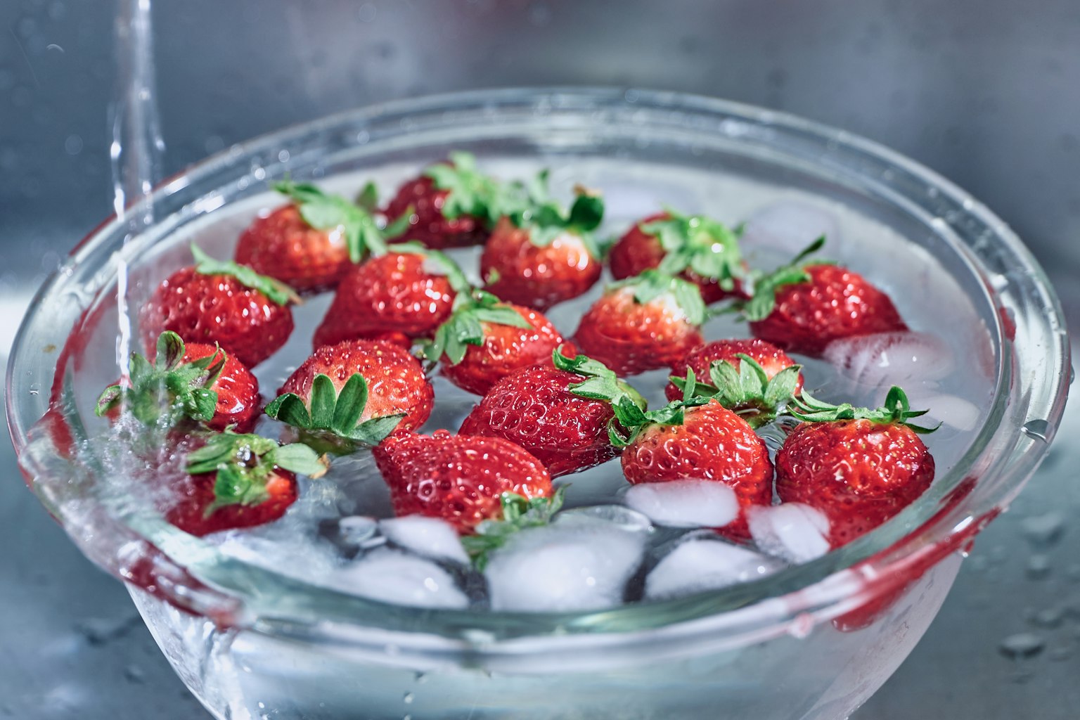 Fresche fragole in una ciotola con ghiaccio e acqua