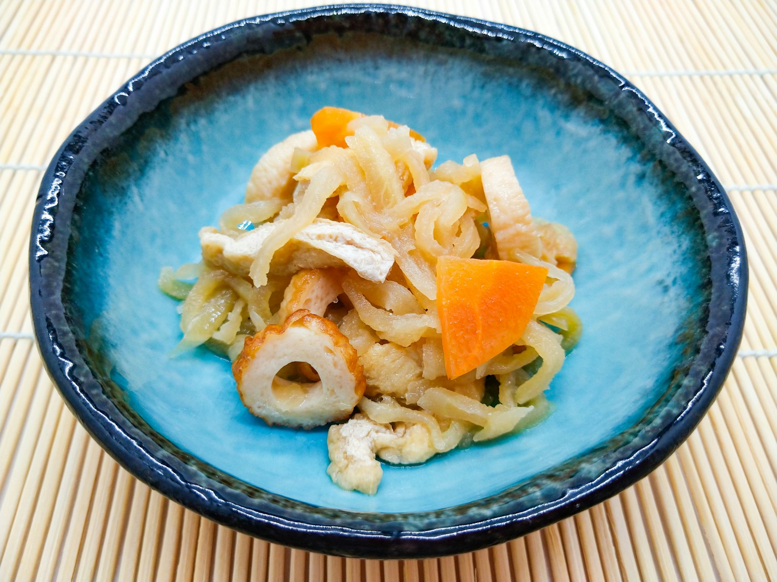 盛在藍色碗中的日本菜餚，包含幹瓢、胡蘿蔔和炸豆腐