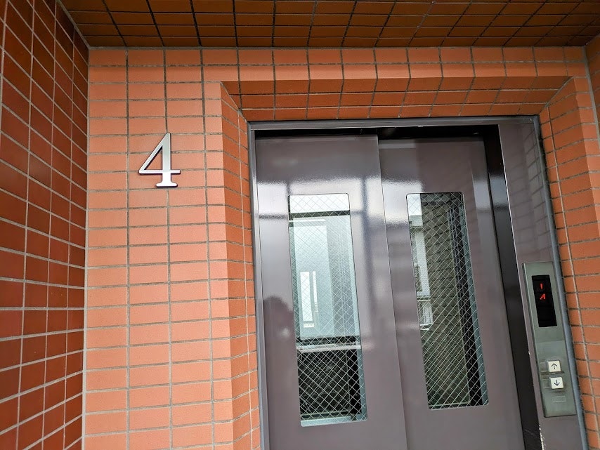 Aufzugsvorraum-Eingang in einem Gebäude mit Ziegelkacheln image