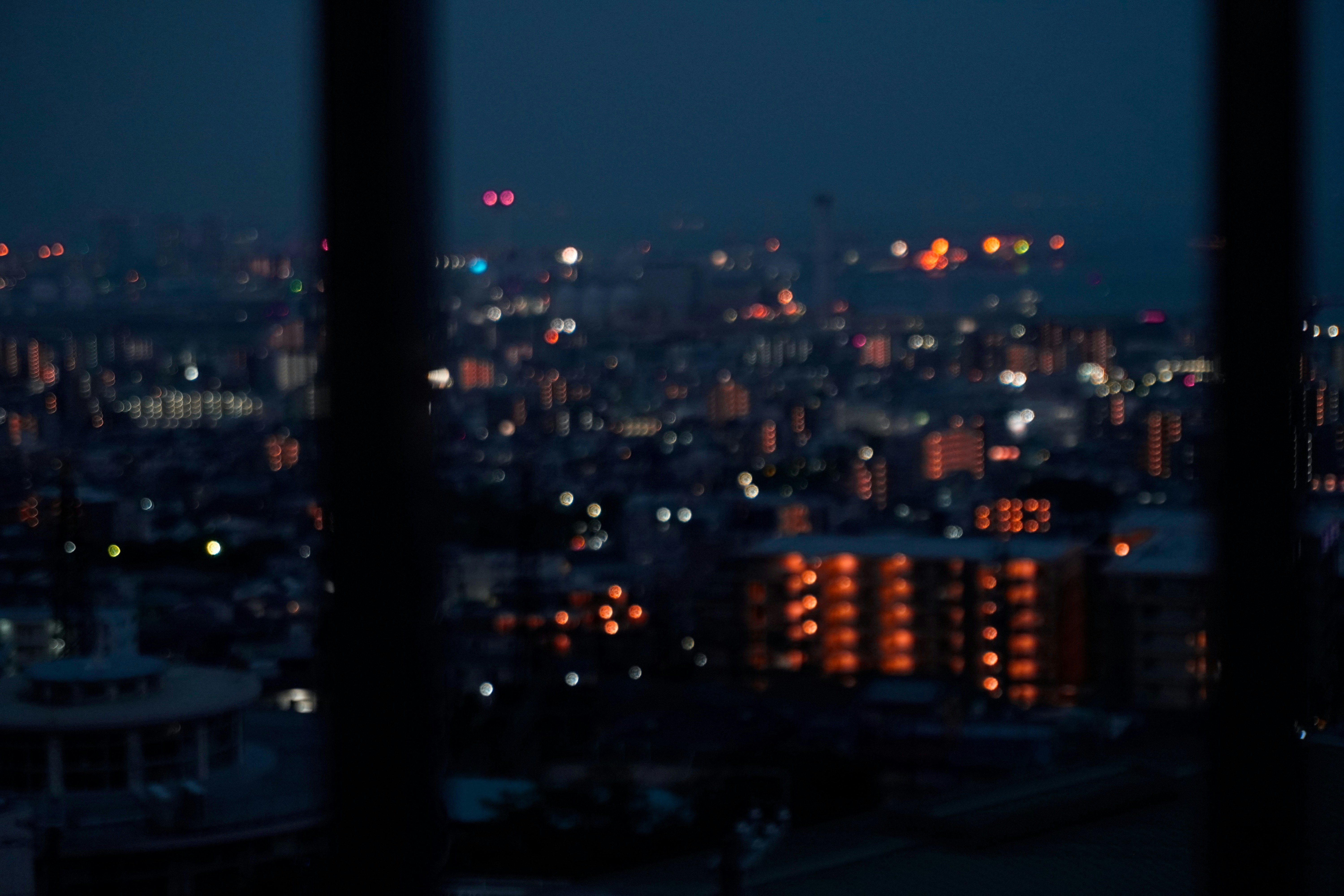 夜景を望む窓越しの都市の灯り