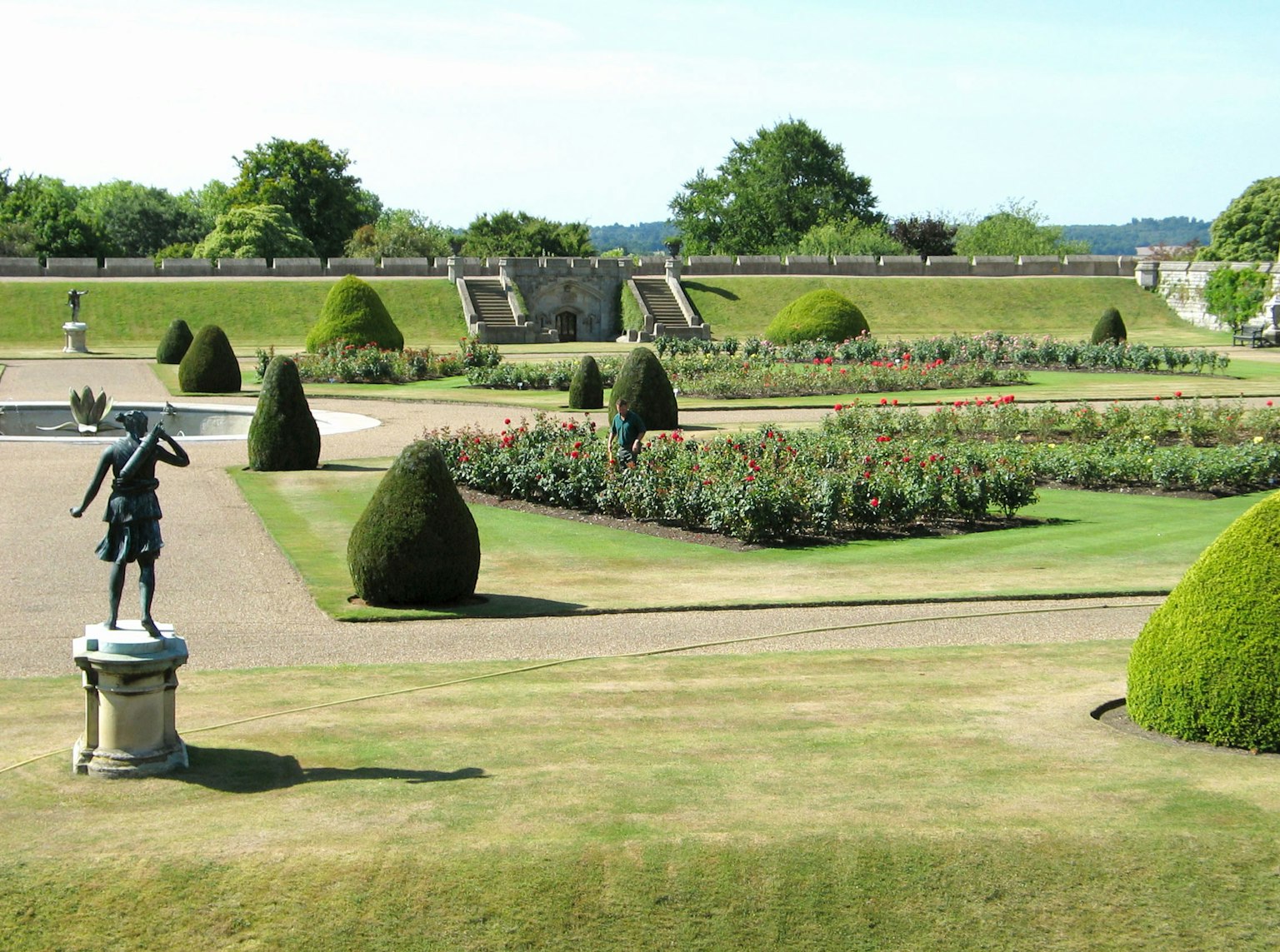 Vue de jardin pittoresque avec une statue et des haies taillées