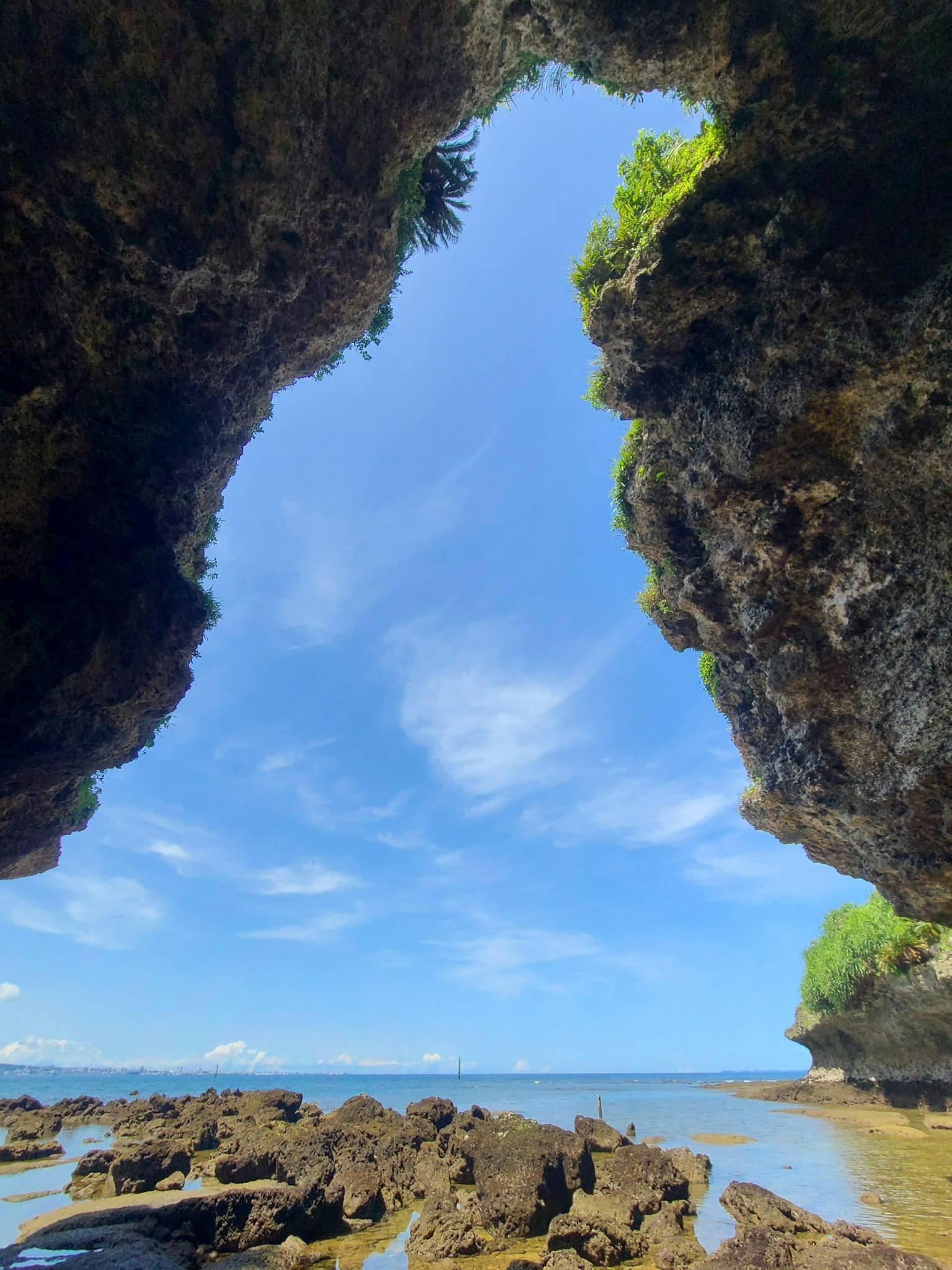 Vista del mar a través de formaciones rocosas bajo un cielo azul