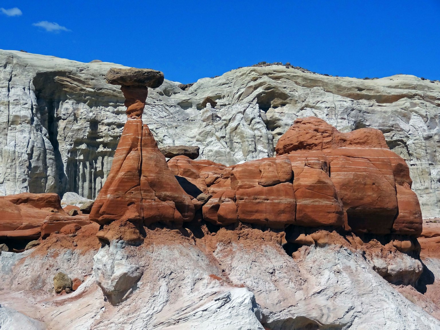 Paesaggio con formazioni rocciose rosse e scogliere stratificate bianche