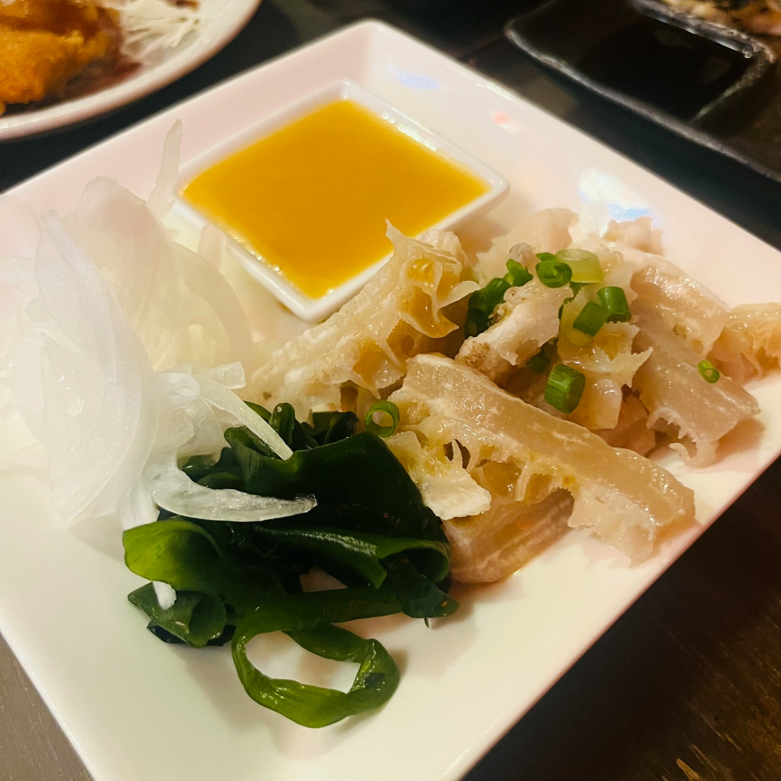 盘子里有切片鸡肉和蔬菜，配有酱汁