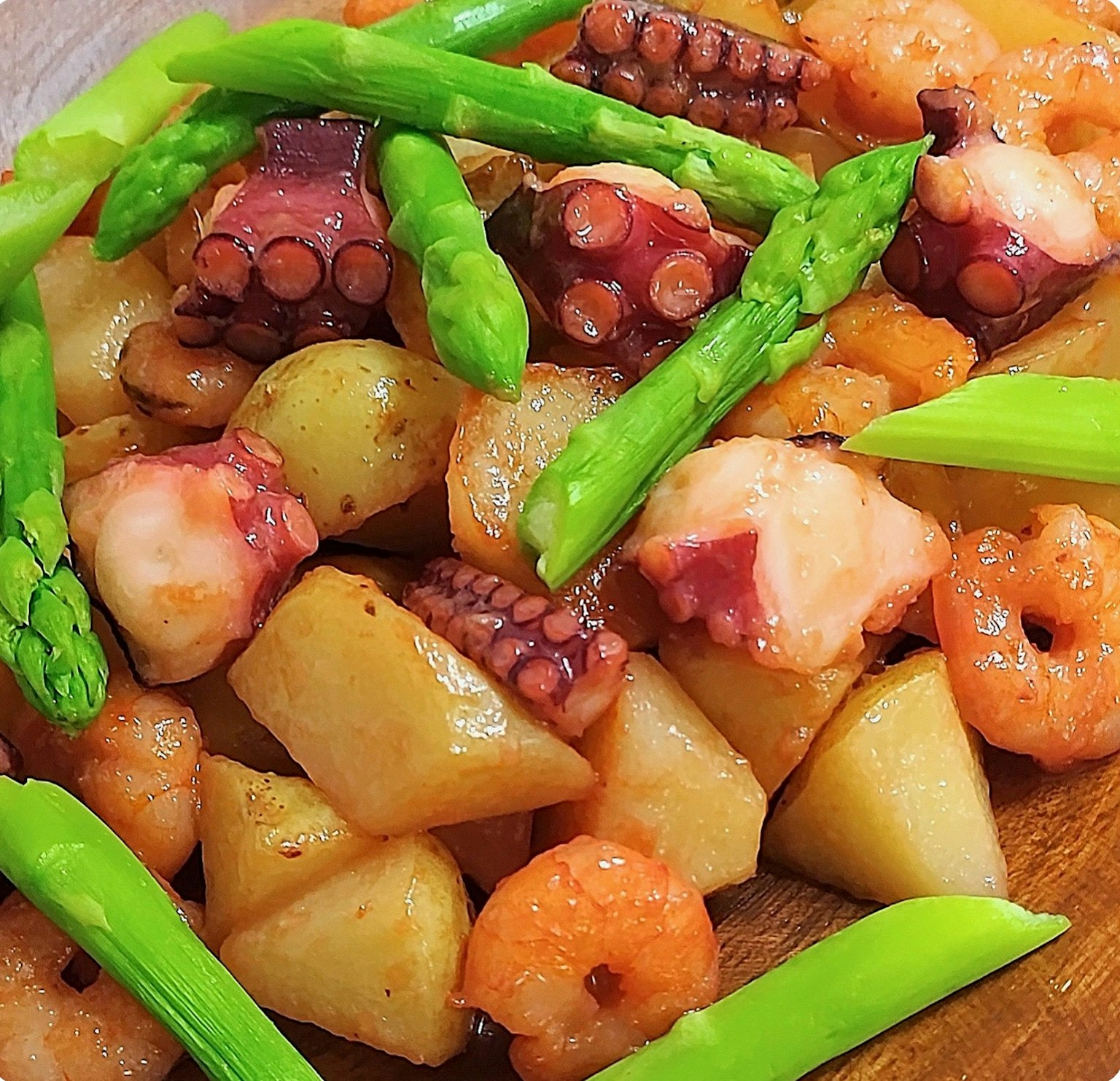 Hidangan berwarna-warni dengan udang dan gurita, disajikan dengan kentang dan asparagus